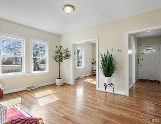 interior space featuring light wood-style flooring, visible vents, and baseboards