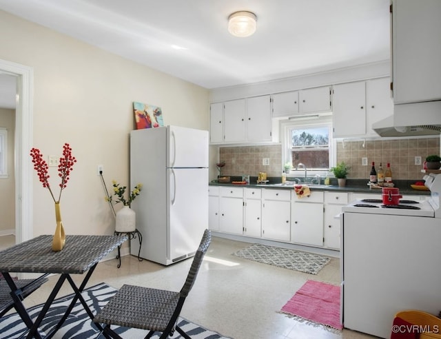 kitchen featuring white cabinets, freestanding refrigerator, electric range oven, tasteful backsplash, and dark countertops