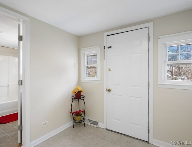 entryway featuring visible vents, tile patterned floors, a wealth of natural light, and baseboards