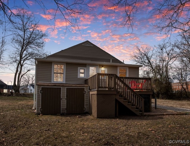 back of property at dusk with stairs and a deck