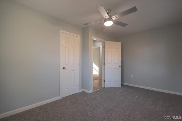 unfurnished bedroom with dark carpet and ceiling fan