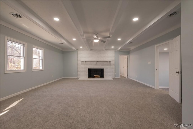 unfurnished living room with ceiling fan, light colored carpet, beam ceiling, and a brick fireplace