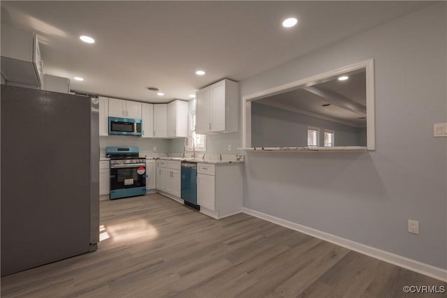 kitchen featuring appliances with stainless steel finishes, light hardwood / wood-style floors, and white cabinets