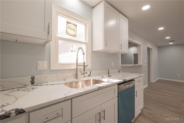 kitchen with sink, light stone counters, stainless steel dishwasher, hardwood / wood-style flooring, and white cabinets