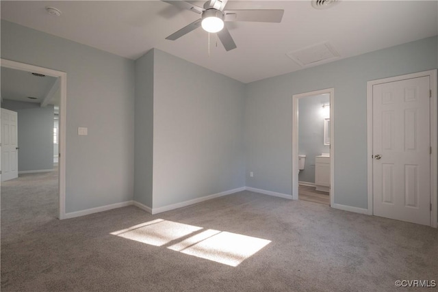 unfurnished bedroom featuring ceiling fan, light colored carpet, and ensuite bath