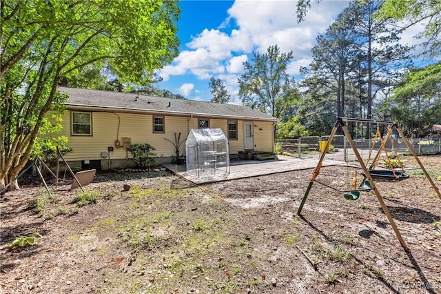 rear view of property with a patio and a playground