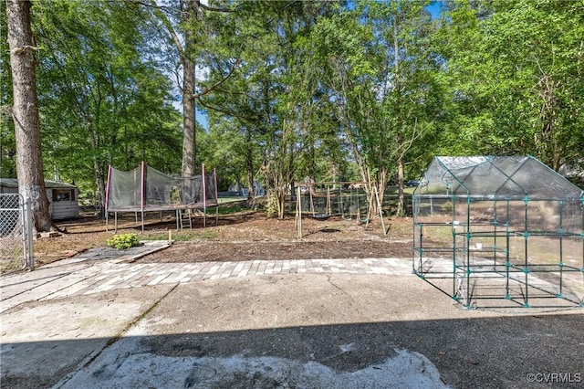 view of yard featuring an outdoor structure and a trampoline