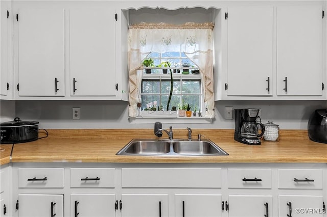 kitchen featuring white cabinetry and sink