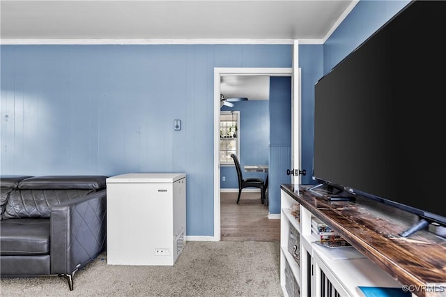 interior space with ceiling fan, light colored carpet, and ornamental molding