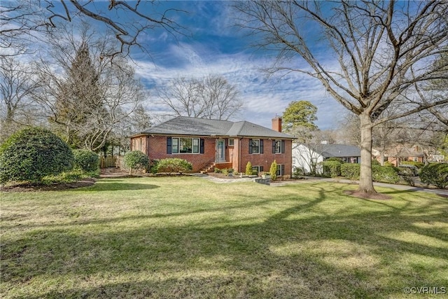 view of front of property featuring a chimney, a front lawn, and brick siding