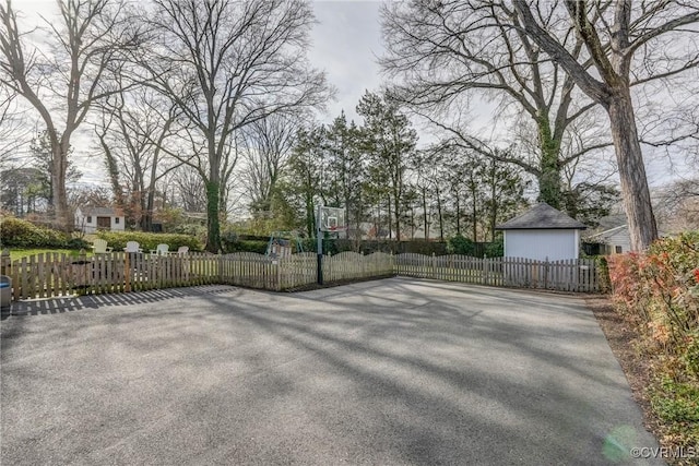 view of patio featuring basketball hoop and fence