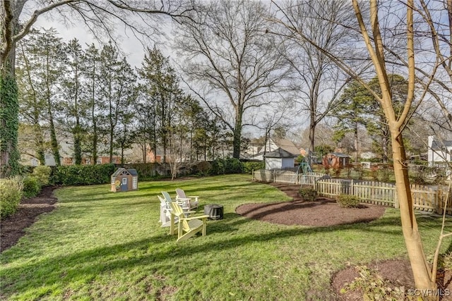 view of yard with an outbuilding, a storage unit, and a fenced backyard