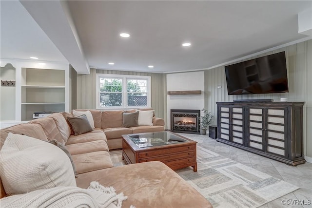 living area with a large fireplace, ornamental molding, and recessed lighting