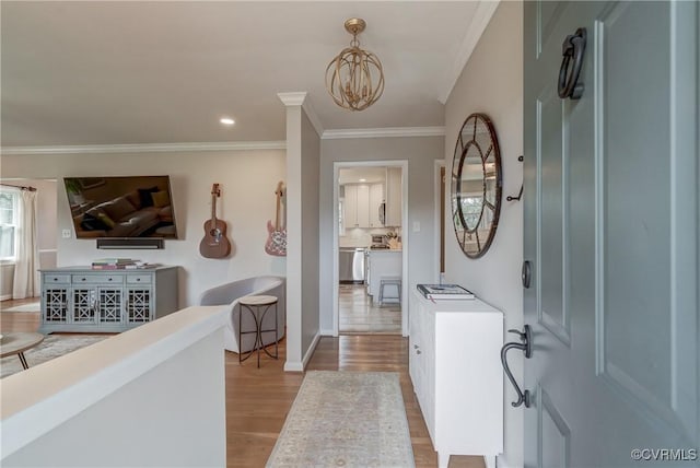 foyer featuring crown molding, recessed lighting, light wood-style flooring, an inviting chandelier, and baseboards