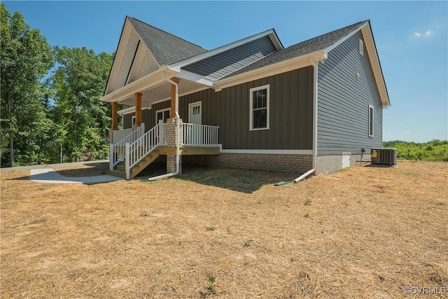 view of front of home with central AC, a porch, and a front yard