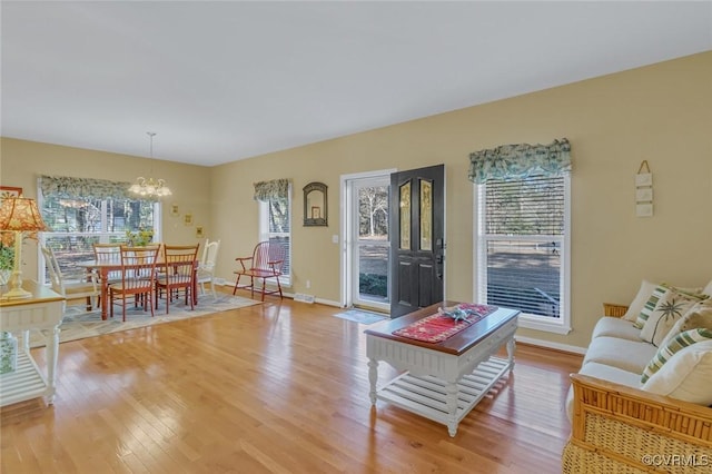 living room with a chandelier and light hardwood / wood-style flooring