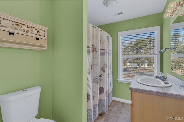 bathroom featuring tile patterned flooring, vanity, walk in shower, and toilet