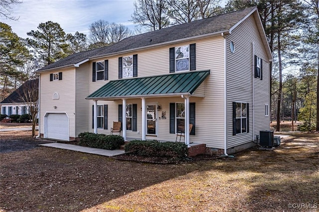 view of front of home with cooling unit, a garage, and covered porch