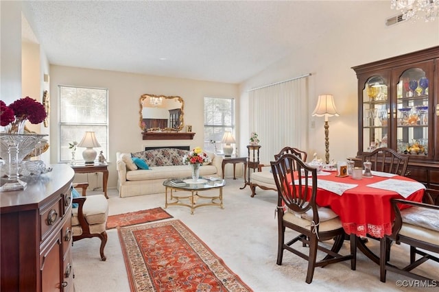 dining space with light carpet, a textured ceiling, and vaulted ceiling