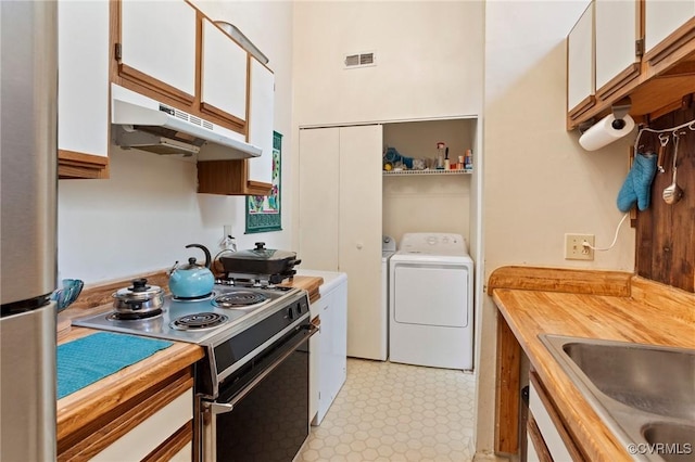 kitchen with electric range oven, under cabinet range hood, separate washer and dryer, and white cabinetry