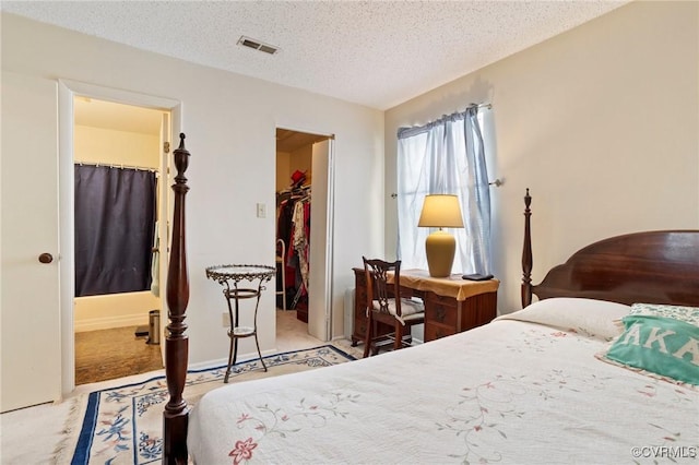 carpeted bedroom with baseboards, visible vents, a spacious closet, a textured ceiling, and a closet