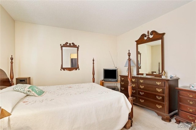 bedroom featuring light carpet and a textured ceiling