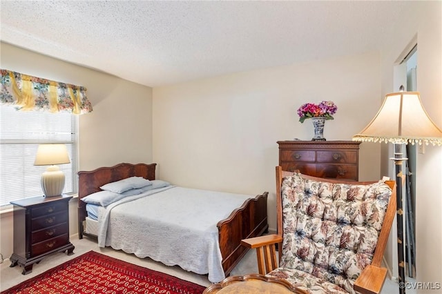 bedroom with a textured ceiling and light colored carpet