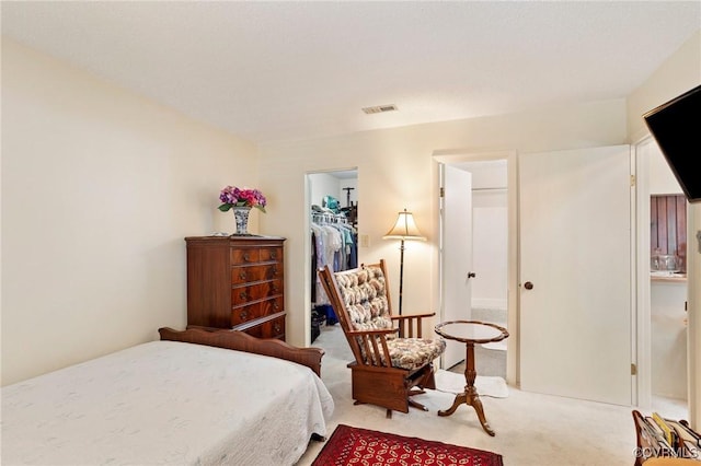 carpeted bedroom with a closet, visible vents, and a spacious closet