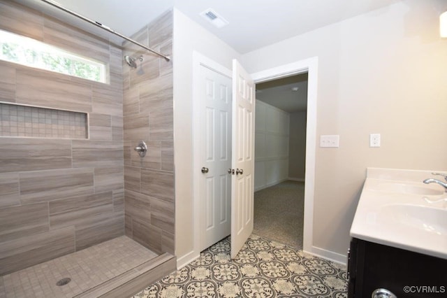 bathroom featuring tiled shower, vanity, and tile patterned floors