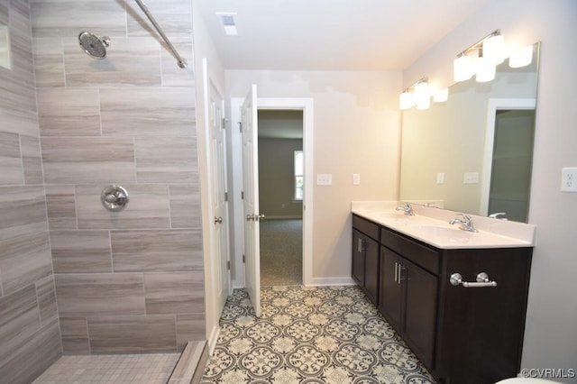 bathroom featuring vanity, tile patterned flooring, and tiled shower