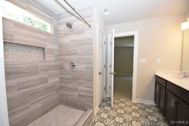 bathroom with vanity, tile patterned floors, and a tile shower