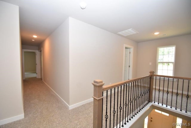 hallway featuring light colored carpet