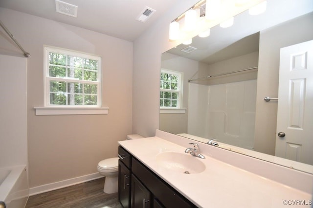 bathroom with plenty of natural light, toilet, wood-type flooring, and vanity