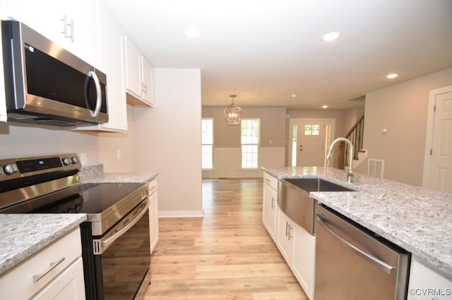 kitchen with appliances with stainless steel finishes, sink, and white cabinets