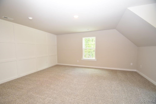 bonus room featuring vaulted ceiling and carpet flooring