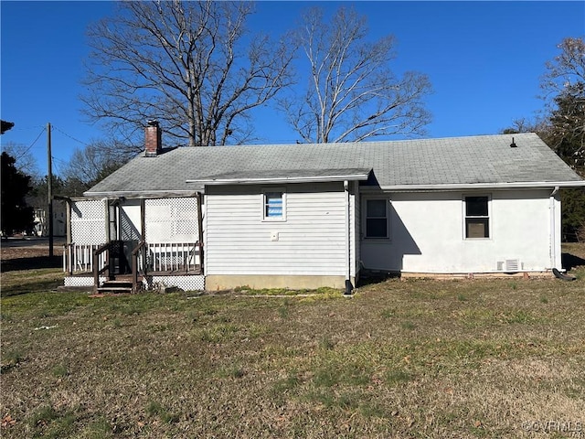 rear view of property with a lawn