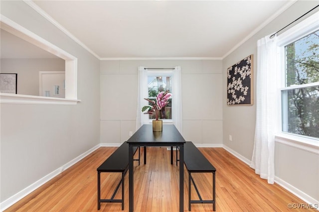 dining room with hardwood / wood-style flooring, ornamental molding, and plenty of natural light