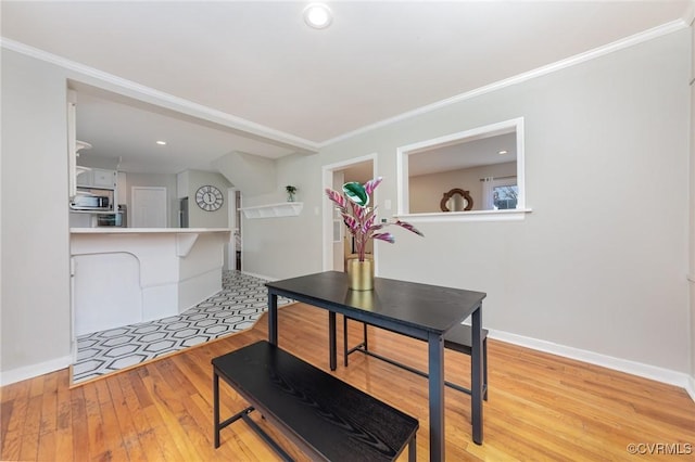 dining area featuring crown molding and light wood-type flooring