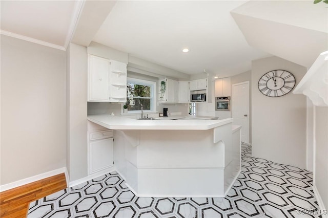 kitchen featuring white cabinetry, sink, a kitchen breakfast bar, kitchen peninsula, and stainless steel appliances