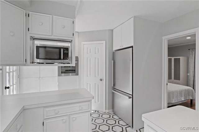 kitchen featuring ornamental molding, appliances with stainless steel finishes, and white cabinets