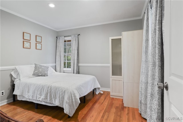 bedroom featuring ornamental molding and light wood-type flooring