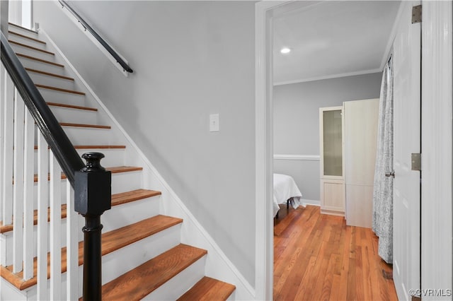 stairway featuring crown molding and wood-type flooring