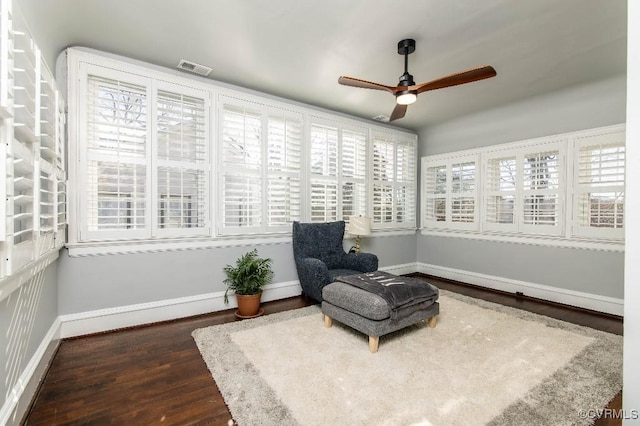 living area featuring ceiling fan and dark hardwood / wood-style flooring