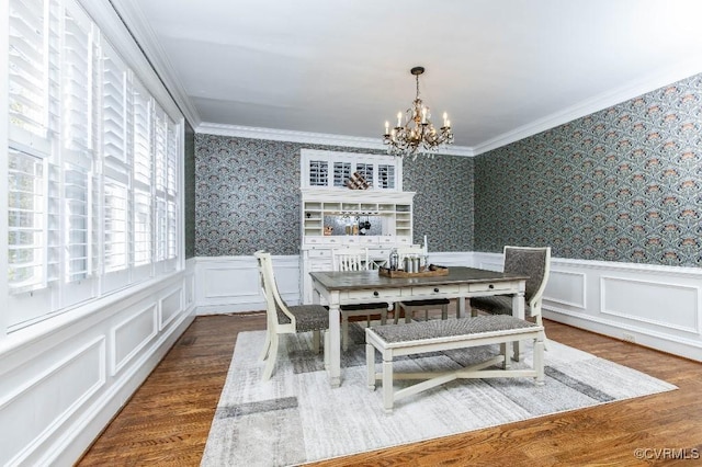 dining room with crown molding, a notable chandelier, and dark hardwood / wood-style flooring