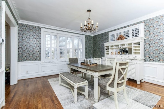 dining room featuring crown molding, wood-type flooring, and an inviting chandelier