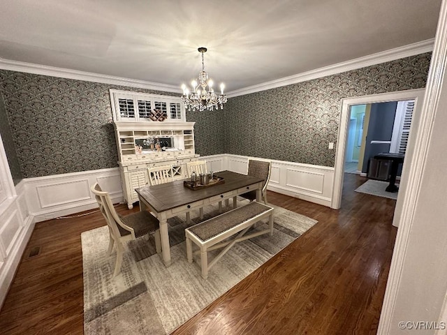 dining room with an inviting chandelier, ornamental molding, and dark hardwood / wood-style flooring