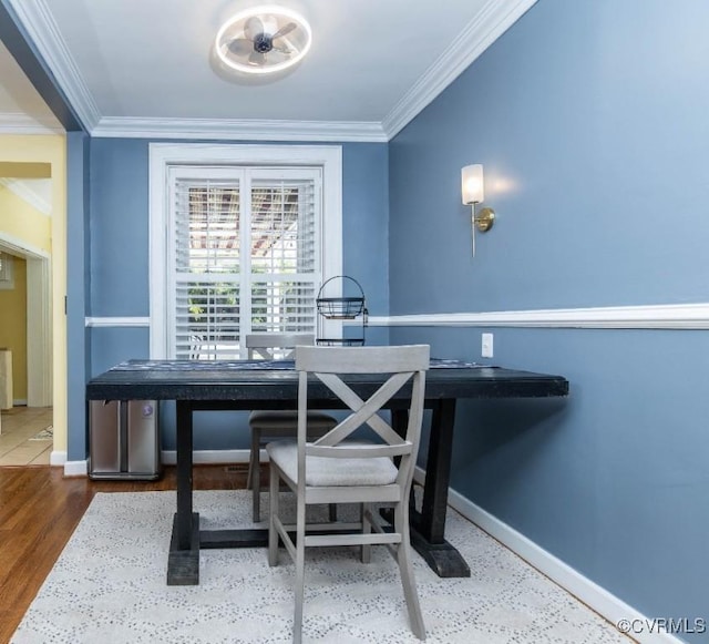 dining area with crown molding and hardwood / wood-style flooring