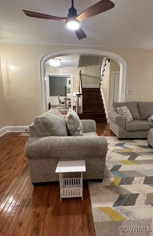 living room featuring ornamental molding, dark wood-type flooring, and ceiling fan