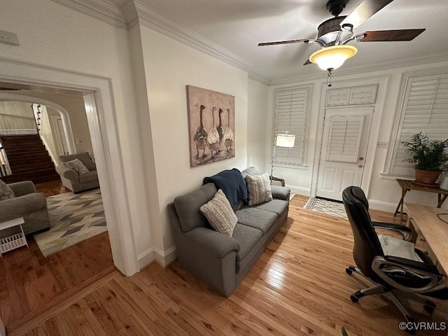 office space featuring ceiling fan, ornamental molding, and light hardwood / wood-style flooring