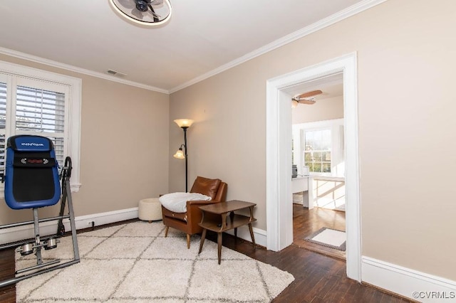 living area featuring hardwood / wood-style flooring, crown molding, and a wealth of natural light